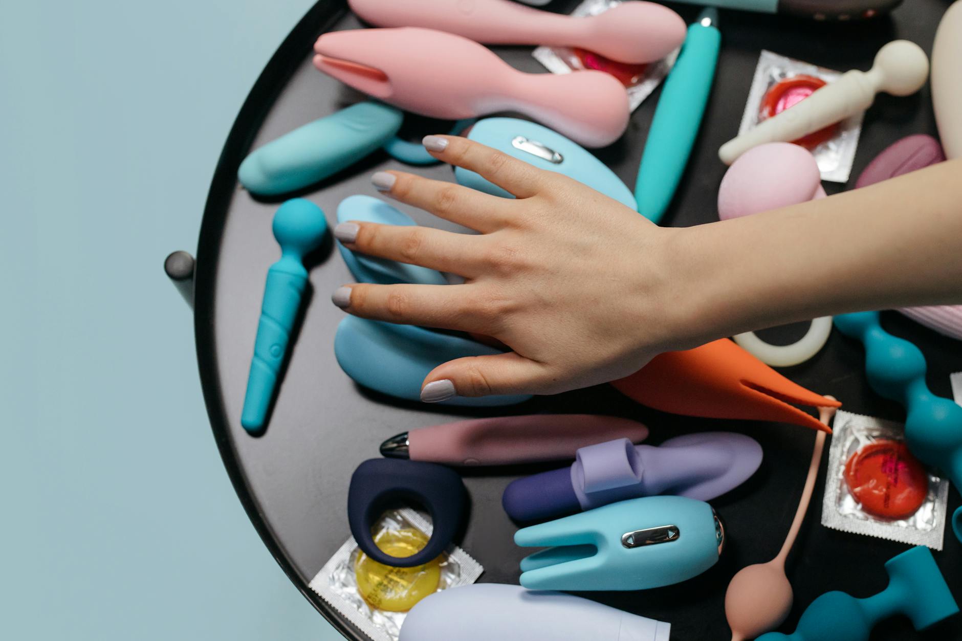 A stylish teal vibrator on smooth white silk fabric, demonstrating texture and sensuality