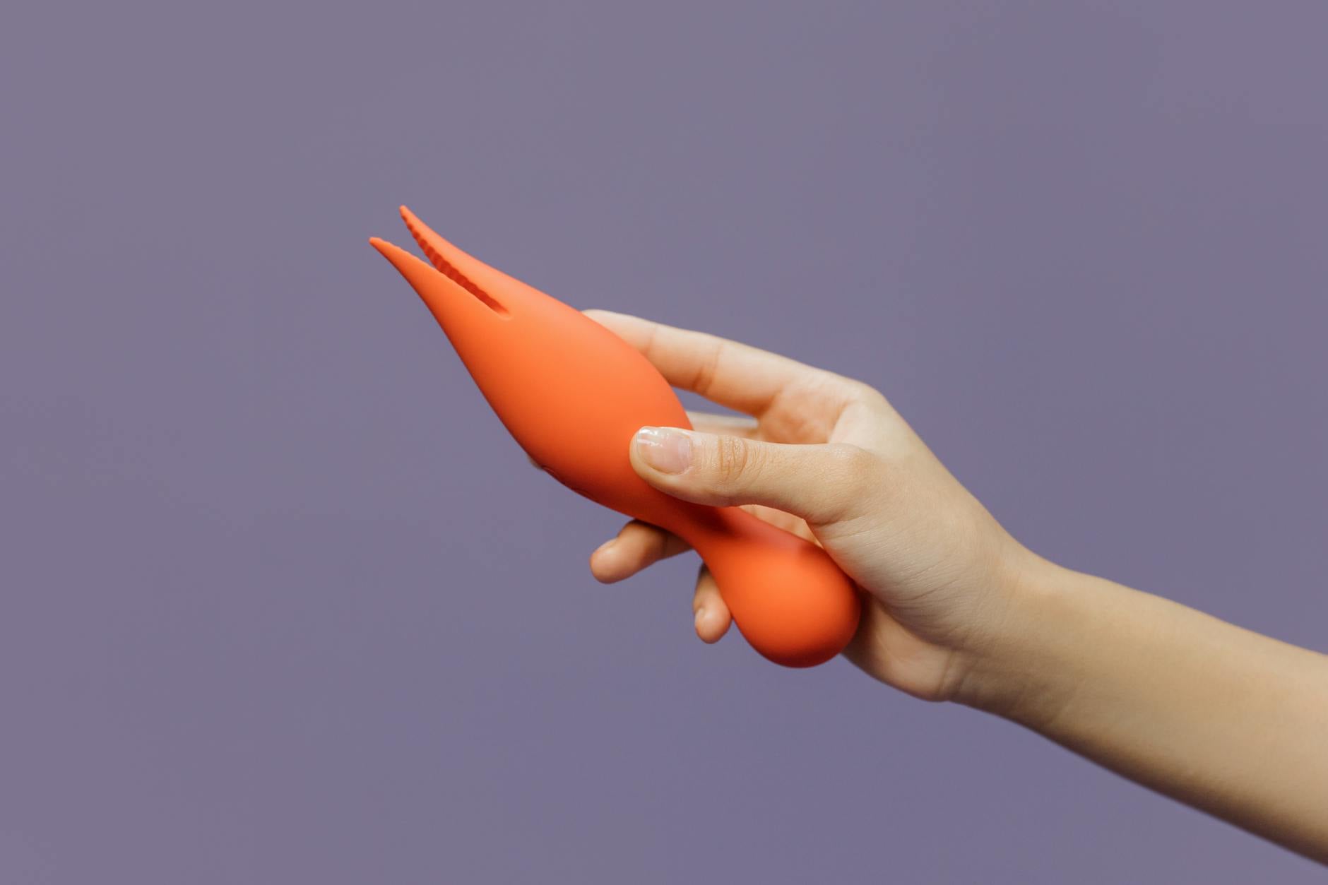 Hand holding a lemon-yellow vibrator against a soft purple background, symbolizing gentle reconnection with pleasure